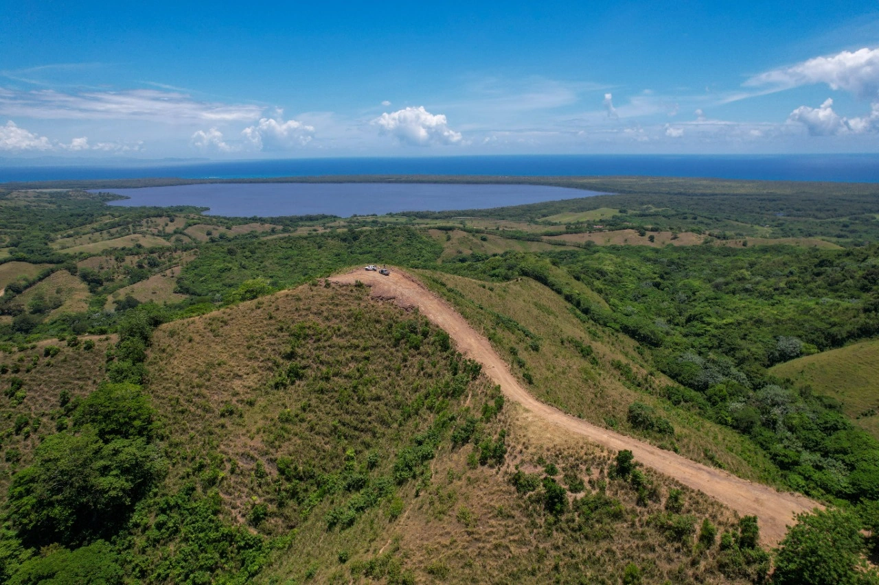 Terreno de montaña frente a una laguna y al océano